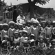 Gruppo di bambini con pagliaccetto e cappellini con le donne istitutrici.